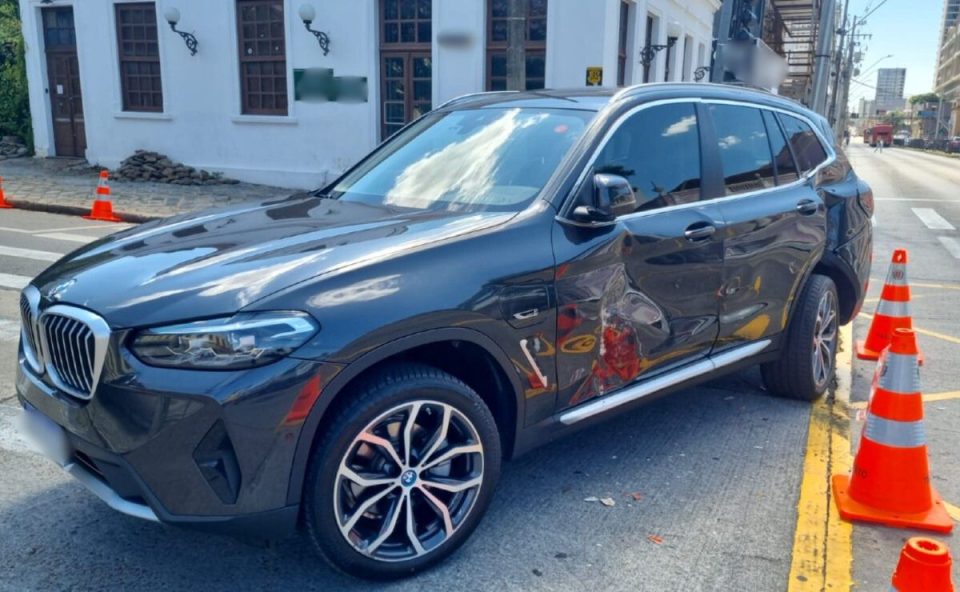 BMW com a lateral amassada depois de acidente com um ônibus biarticulado em um cruzamento no bairro Rebouças, em Curitiba.