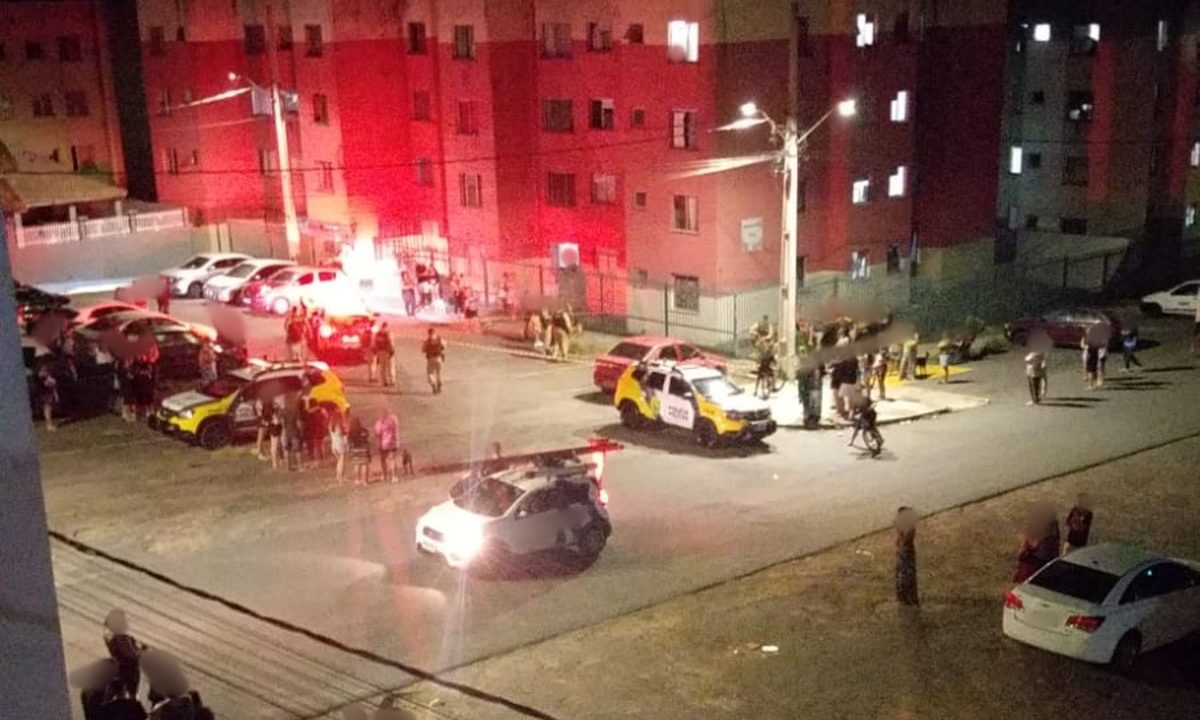 Foto mostra movimentação de moradores e policiais militares em condomínio onde homens invadiram e mataram mulher a tiros, em São José dos Pinhais