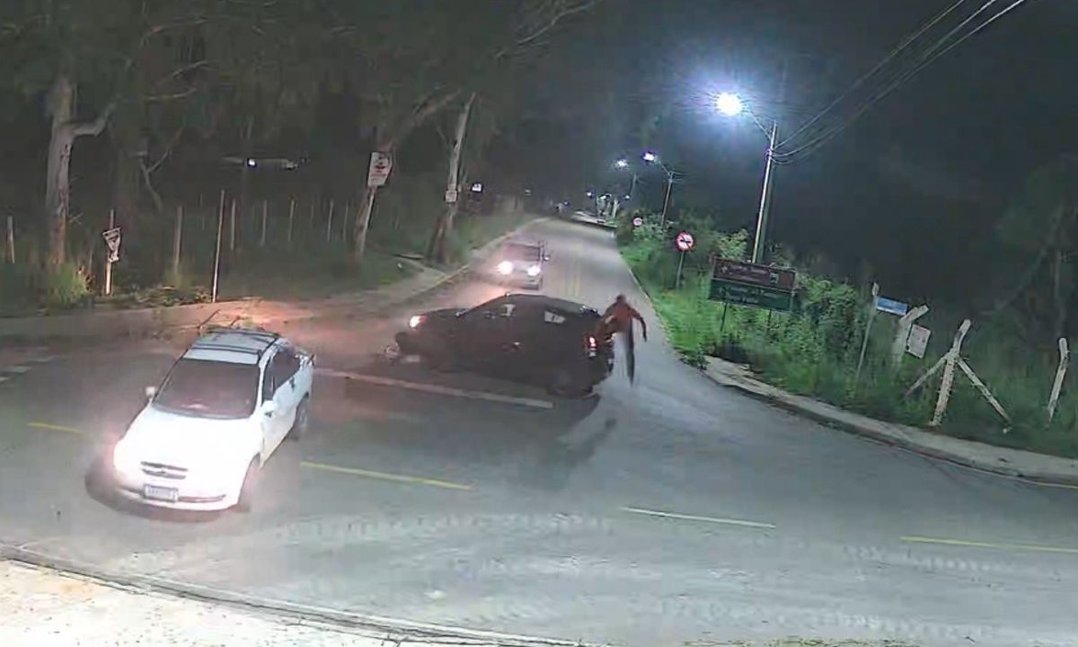 Imagem de câmera de segurança mostra ex-namorado fugindo de tentativa de sequestro em cruzamento à noite, enquanto a mulher está dentro do carro. Ela foi presa pelo crime.