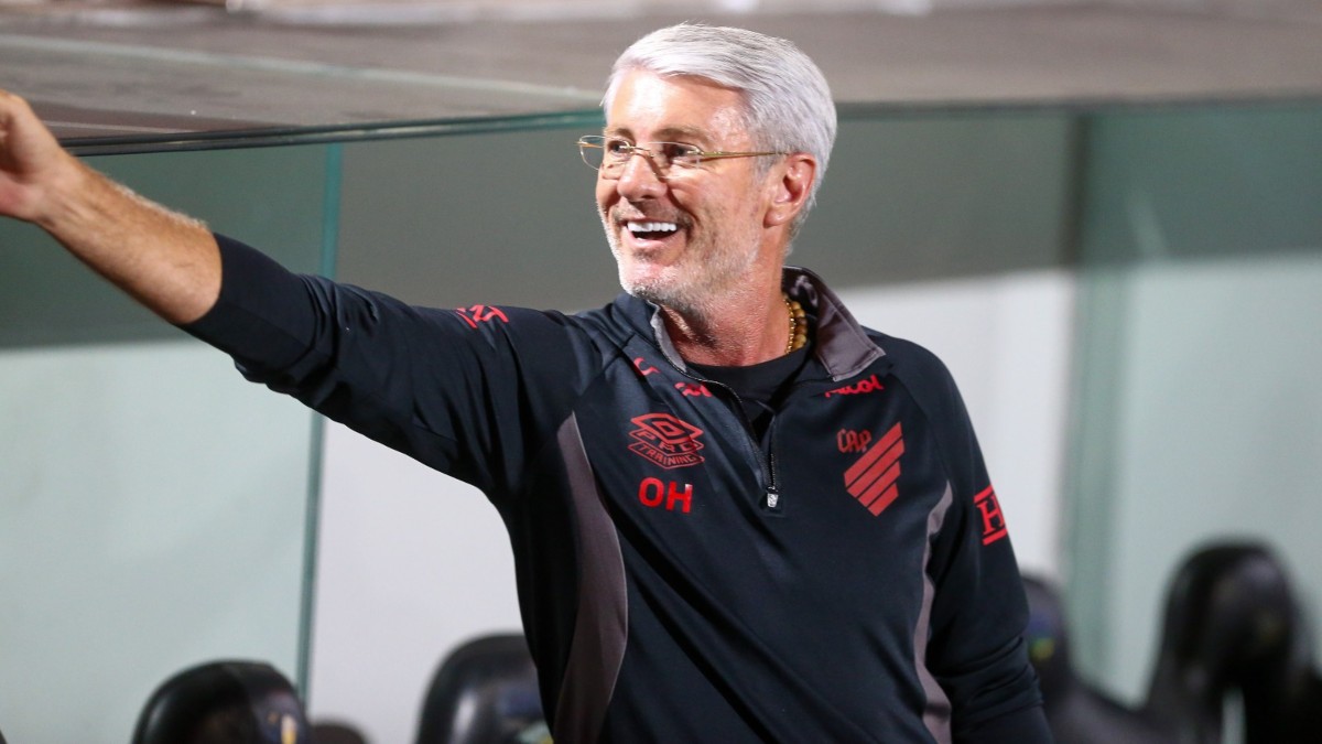 Técnico do Athletico, Odair Hellmann, sorri e cumprimenta desconhecido do banco de reservas da Arena da Baixada