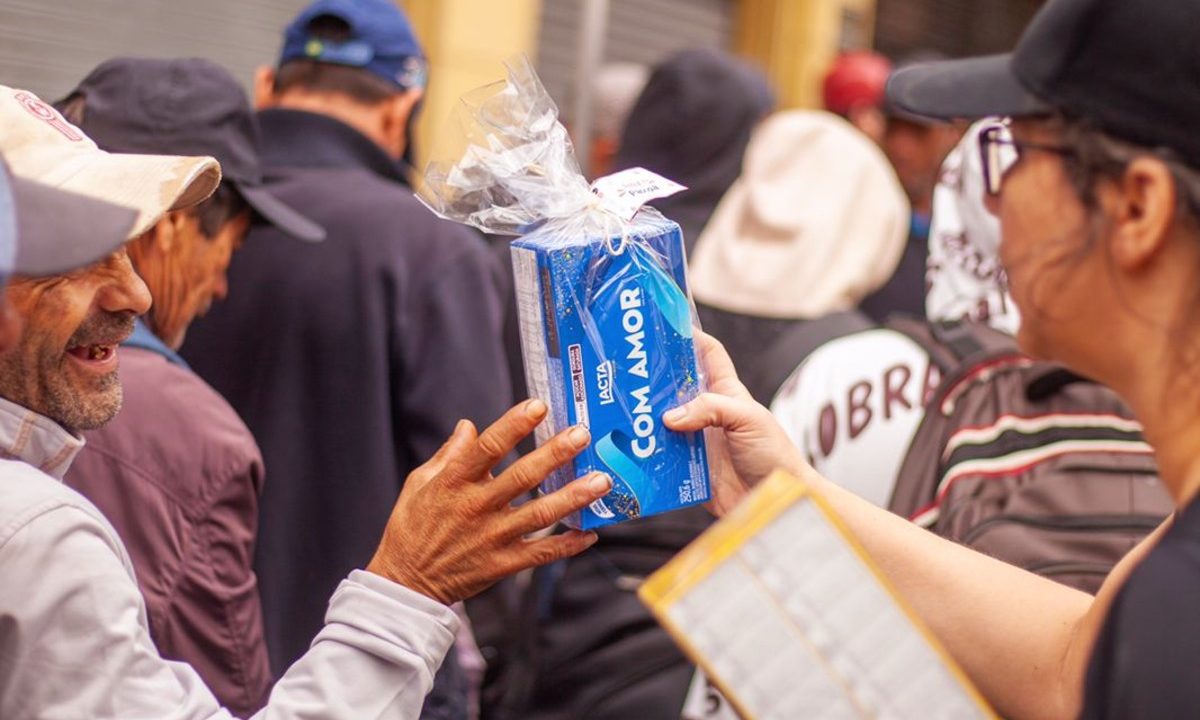 pessoa em situaçaõ de rua recebendo chocolate de Páscoa da campanha solidária em curitiba