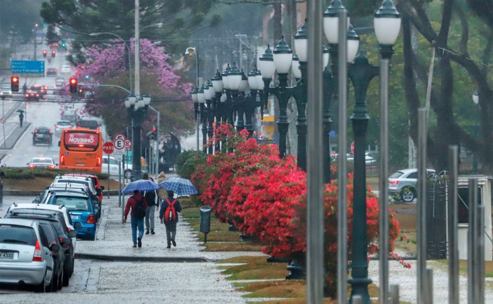 foto de pessoas andando com sombrinha em curitiba para ilustrar a previsão de chuva no paraná