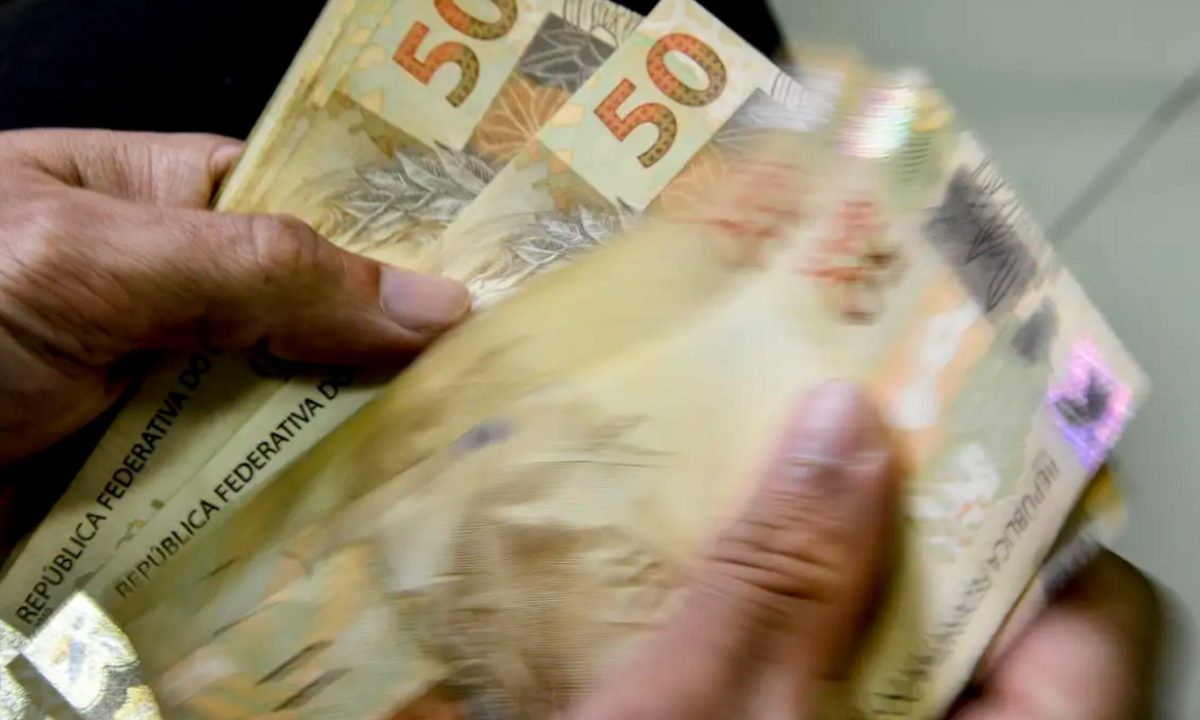 Foto de mão contando dinheiro do resultado da lotofácil 3641