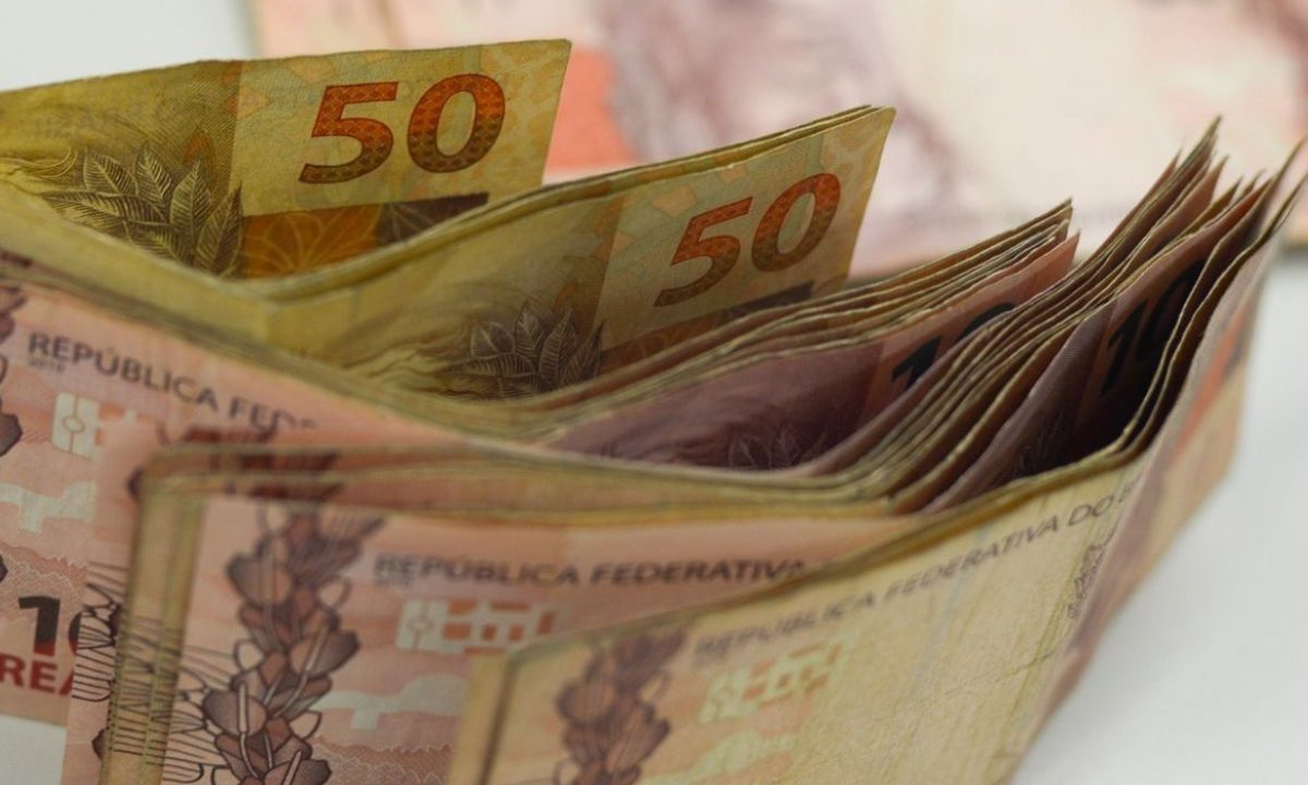 Foto de cédulas de reais em pé, em cima de uma mesa; imagem utilizada para ilustrar dinheiro recebido com o resultado da Lotofácil
