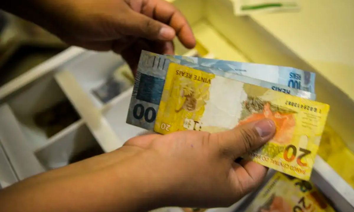Foto de mão contando cédulas de reais; dinheiro usado para ilustrar o valor que a aposta do paraná ganhou no resultado da quina 6982
