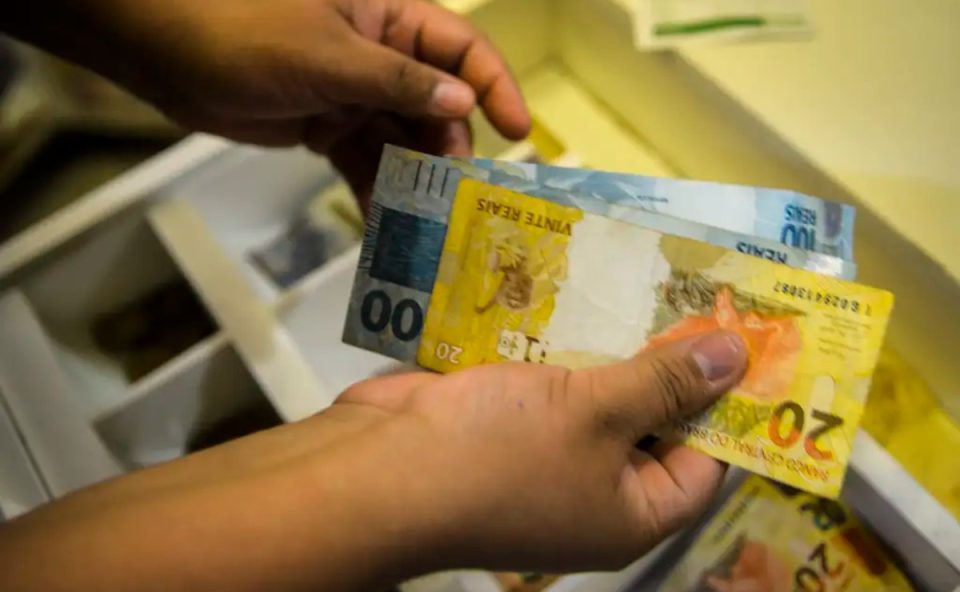 Foto de mão contando cédulas de reais; dinheiro usado para ilustrar o valor que a aposta do paraná ganhou no resultado da quina 6982