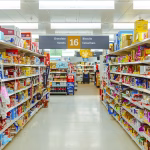 Foto mostra corredor de supermercado com gôndolas cheias, mas ninguém caminhando entre elas. Foto faz alusão à possibilidade de supermercados serem proibidos de abrir aos domingos