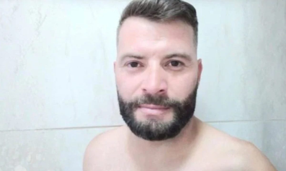 Imagem mostra a vítima Jean, morto a facadas pelo amigo em Santa Felicidade. O suspeito se apresentou na delegacia, ficou em silêncio e foi liberado. A imagem mostra um homem com cabelo escuro, com barba e bigode escuros também. Ele está sem camisa, com o cabelo cortado.