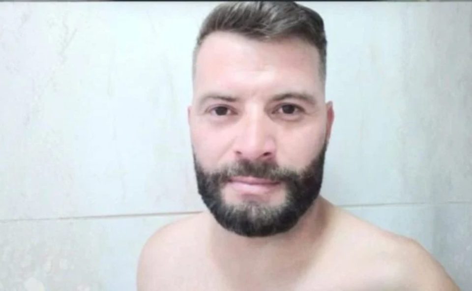 Imagem mostra a vítima Jean, morto a facadas pelo amigo em Santa Felicidade. O suspeito se apresentou na delegacia, ficou em silêncio e foi liberado. A imagem mostra um homem com cabelo escuro, com barba e bigode escuros também. Ele está sem camisa, com o cabelo cortado.