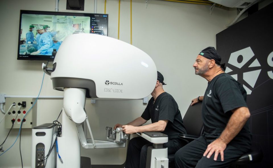 Médico opera robô cirúrgico em telecirurgia inédita no Brasil em sala equipada com monitor que transmite cirurgia em tempo real