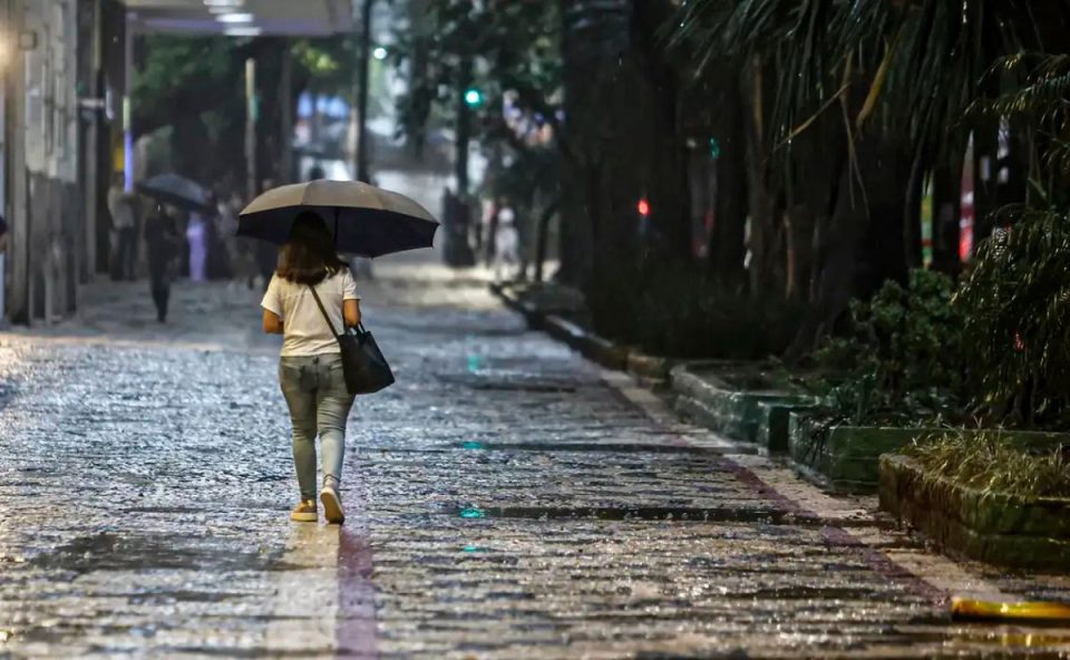 mulher andando com sombrinha para ilustrar a previsão do tempo com chuva no paraná e em curitiba 