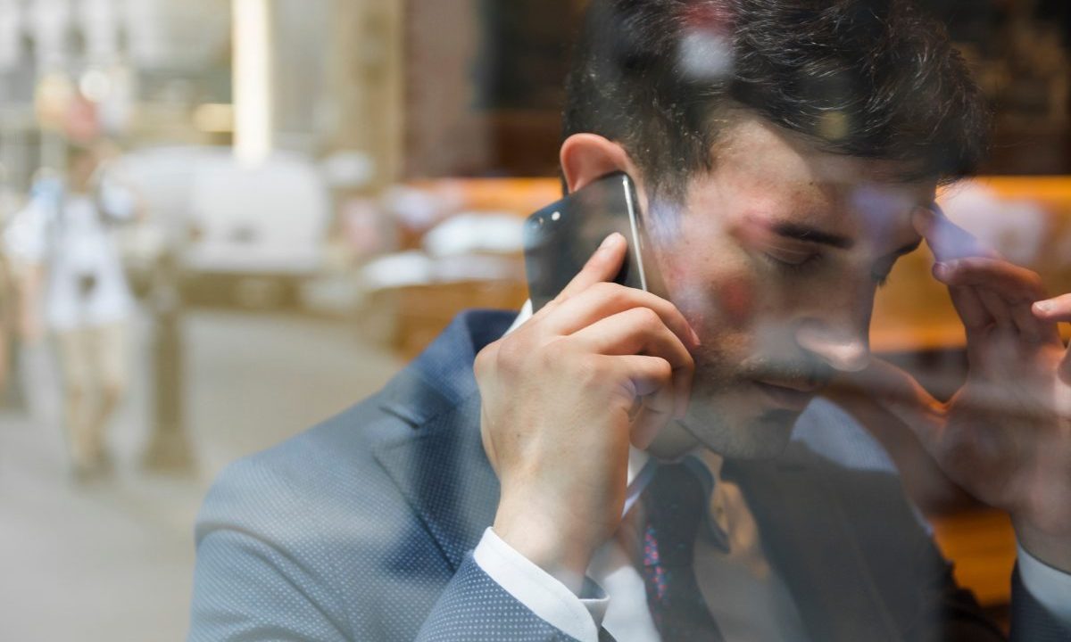 Imagem ilustrativa de tentativa de golpe em consultório odontológico. Homem no celular.