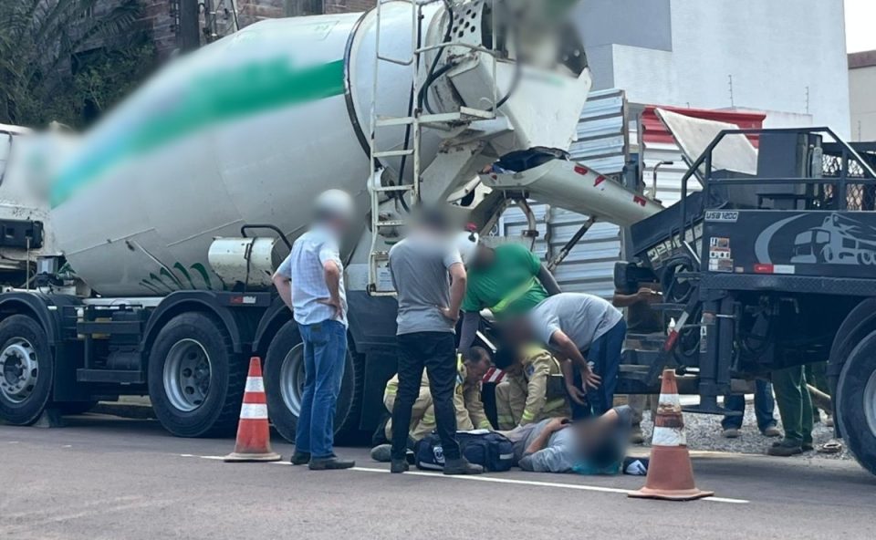 Colegas de trabalho prestam assistência a trabalhador que teve perna prensada por caminhão-betoneira durante manobra em obra em Curitiba
