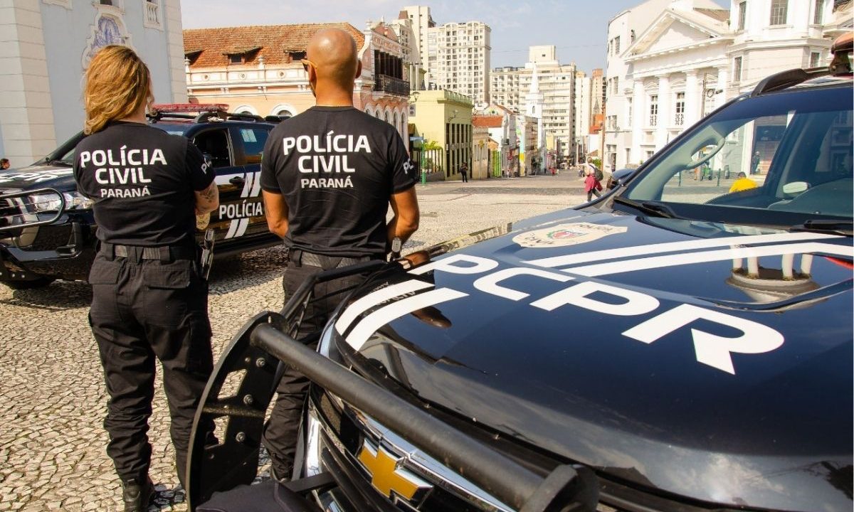 Comissão na Câmara dos Deputados aprovou gratuidade do transporte público para agentes de segurança (policias civis e militares). A imagem mostra polciais civis próximos a duas viaturas, no Centro de Curitiba.