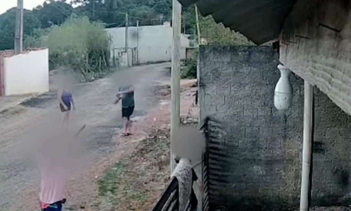 Vizinhos realizando ataque de tijolos contra casa de mulher