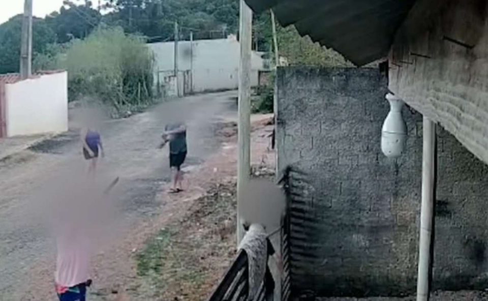 Vizinhos realizando ataque de tijolos contra casa de mulher