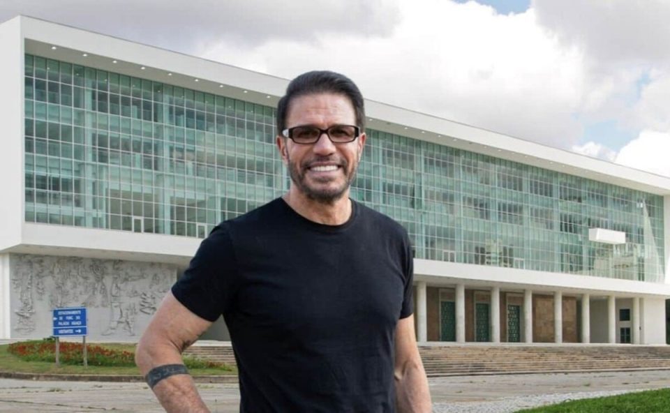 Tony Garcia é candidato a governador. Ele aparece em frente ao Palácio Iguaçu vestindo camiseta preta e sorrindo
