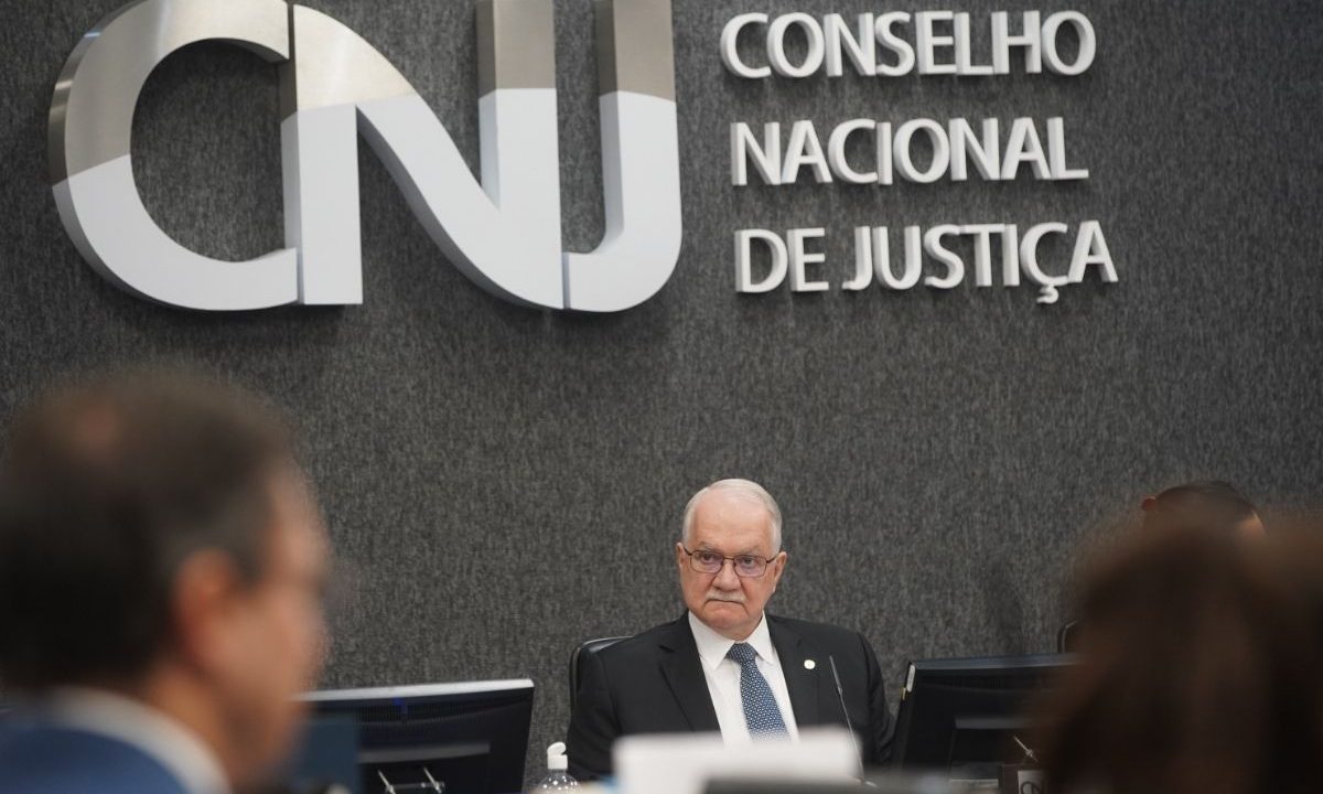O ministro Edson Fachin, presidente do CNJ, sentado em uma reunião, com o logotipo do Conselho Nacional de Justiça ao fundo