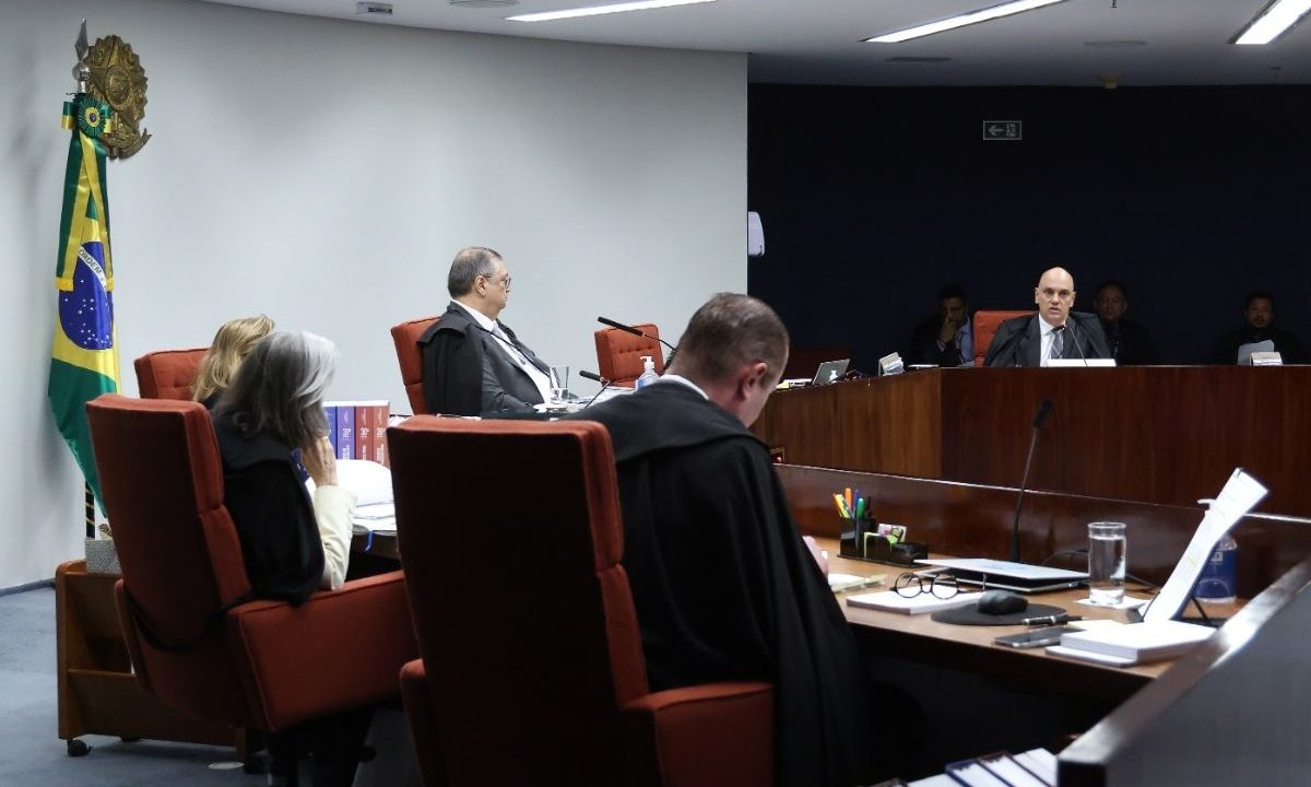 Ministros da Primeira Turma do STF, incluindo Alexandre de Moraes e Flávio Dino, sentados em cadeiras vermelhas durante sessão de julgamento