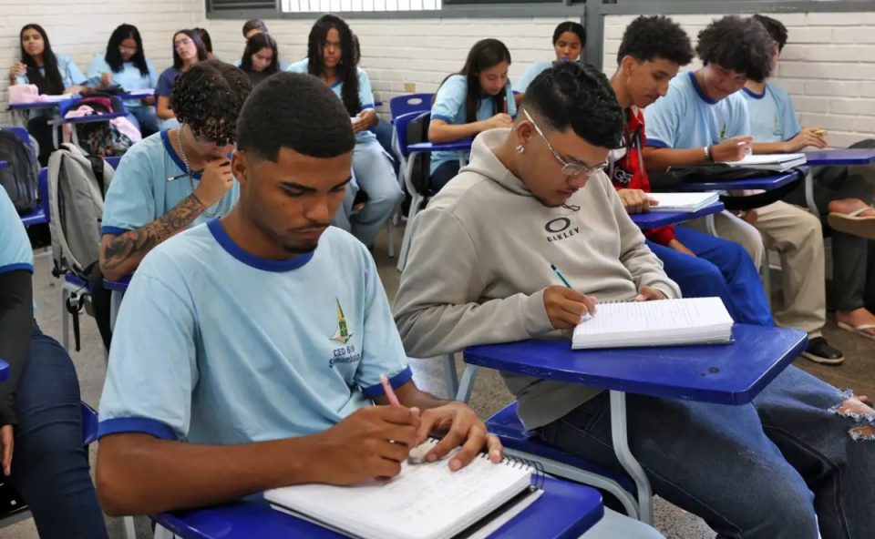 Estudantes em sala de aula, escrevendo em seus cadernos. Imagem ilustrativa para matéria sobre inscrições para vagas remanescentes do Fies