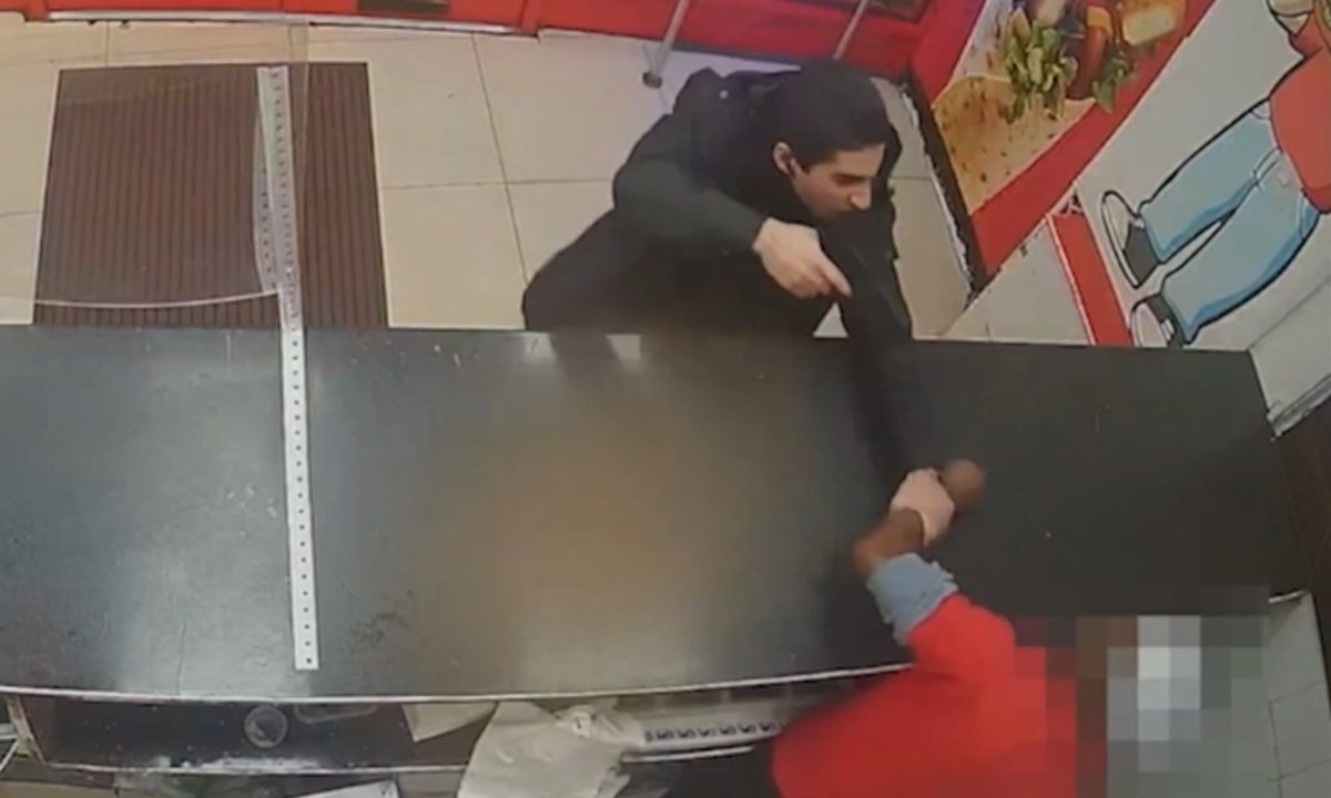 A imagem mostra a ameaça em um fast-food, com o agressor apontando uma arma falsa à vítima.