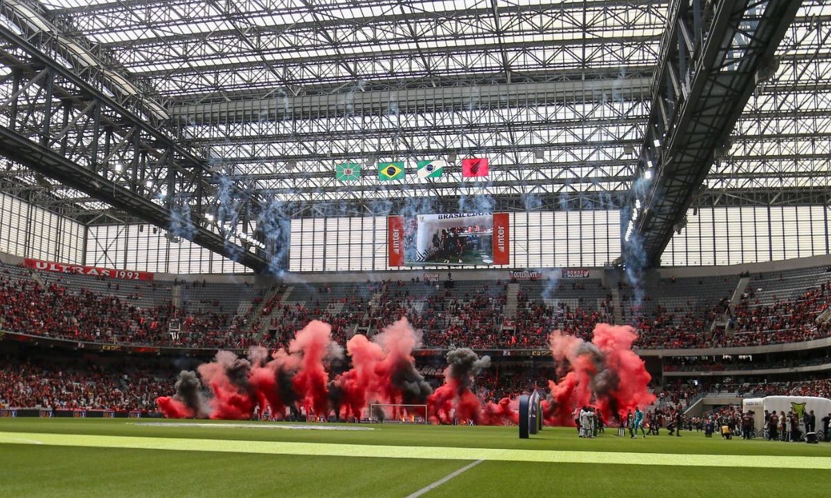 Torcida do Athletico na Arena da Baixada com sinalizadores durante partida, ilustrando receitas de estádio no balanço financeiro de 2025