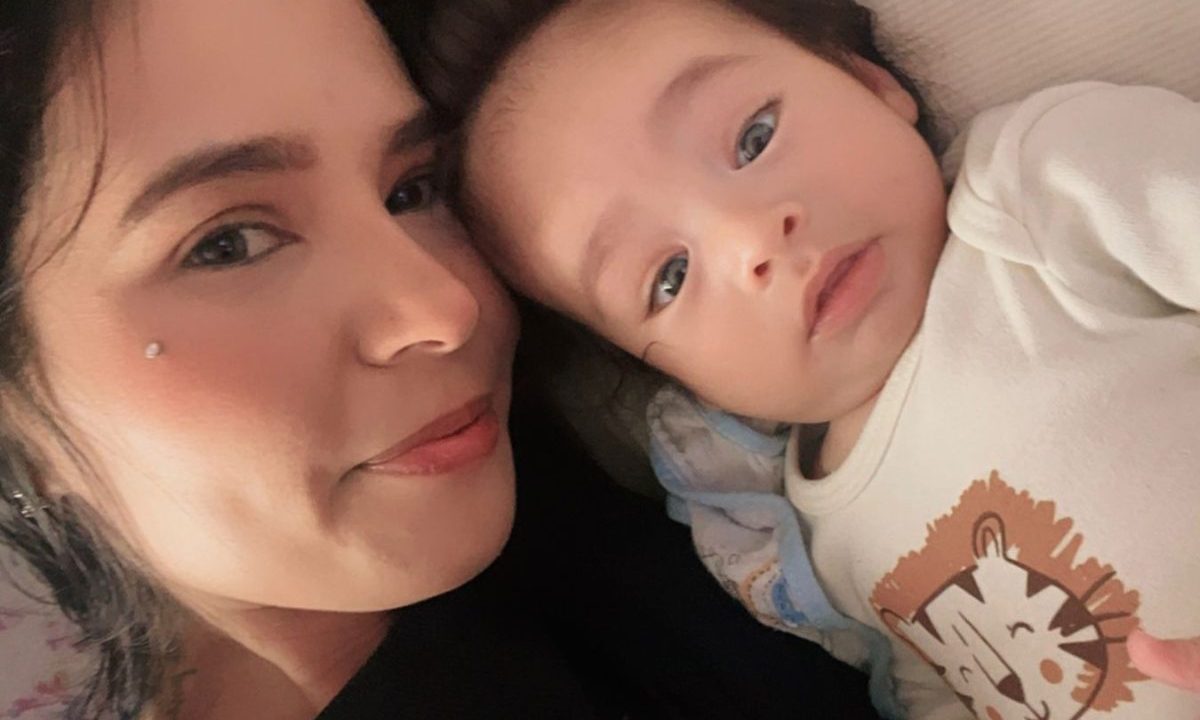 Mãe aparece deitada ao lado de bebê de seis meses que recebe tratamento para hemofilia no Paraná