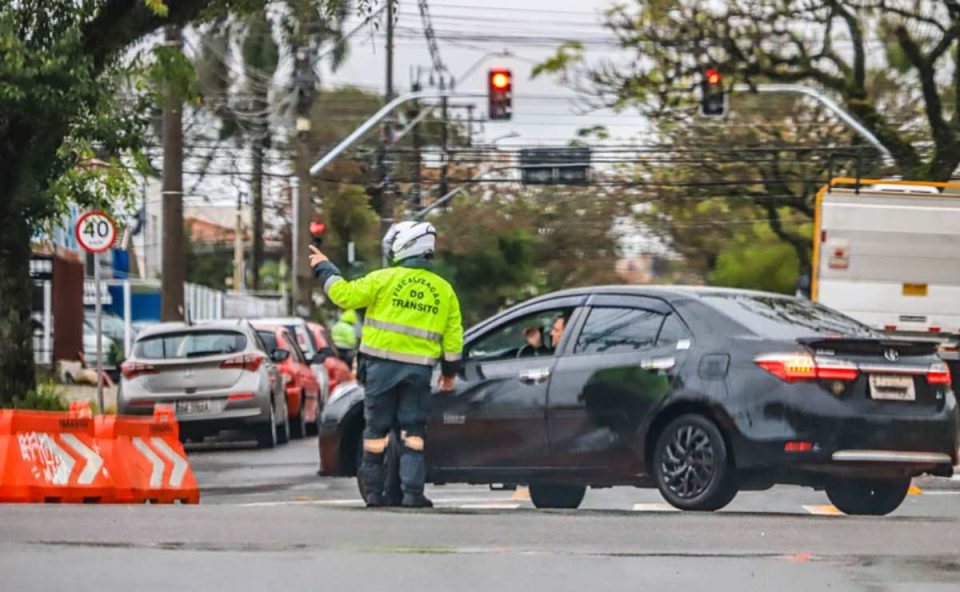 Agente orientando motorista em local com bloqueio de trânsito em Curitiba