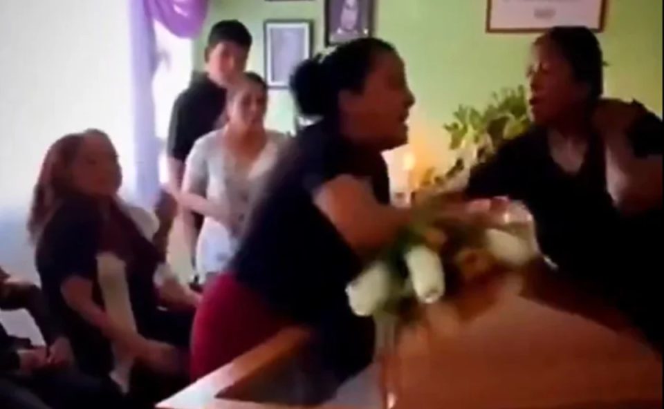 Foto mostra a briga entre duas mulheres em cima de caixão durante velório