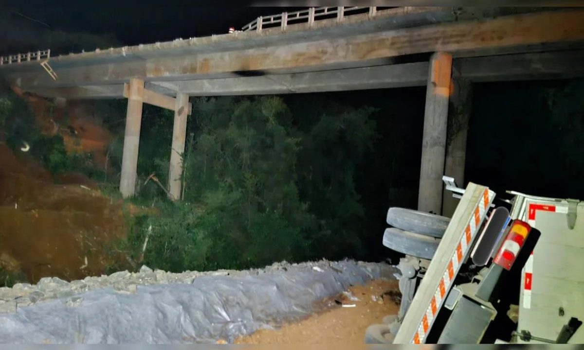 Caminhão que despencou da ponte caído de lado em estrada