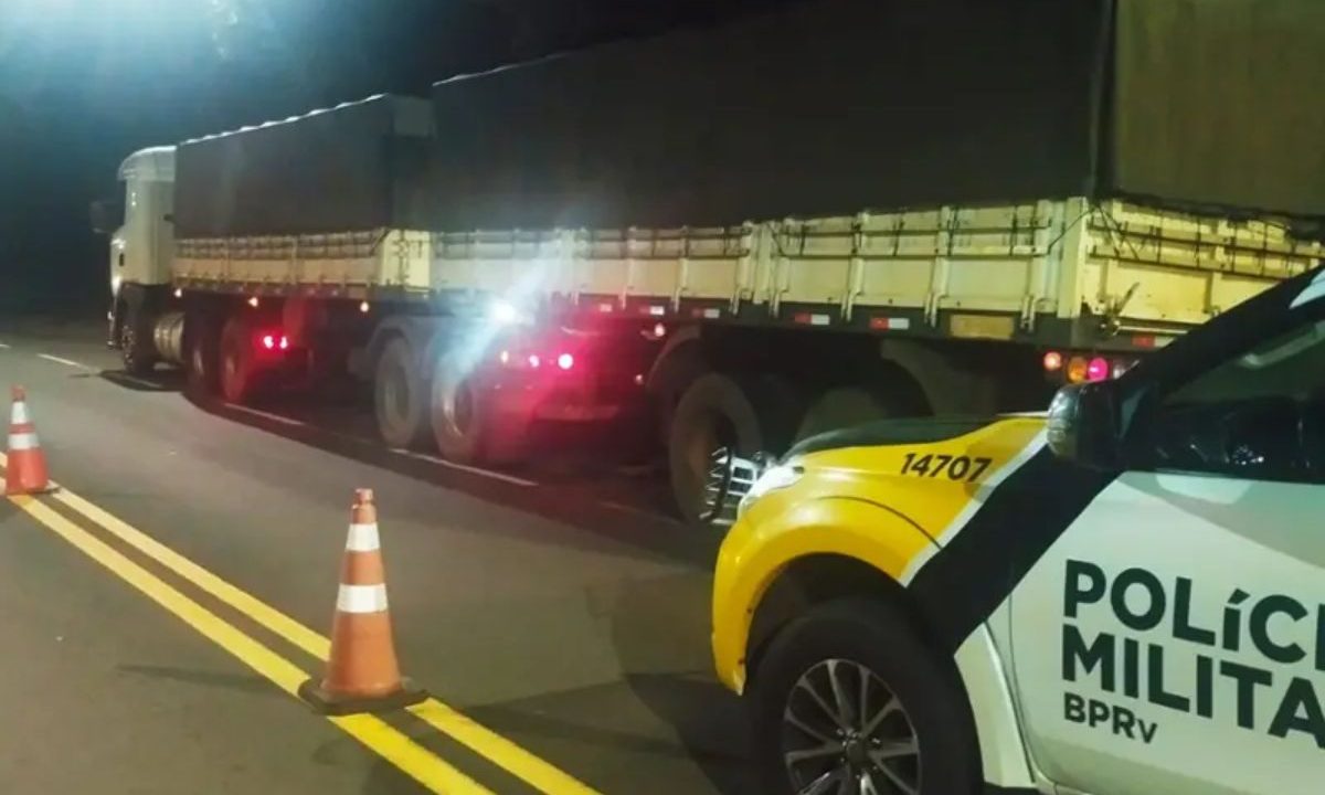 Caminhão de feijão parado na estrada atrás de viatura da Polícia Militar