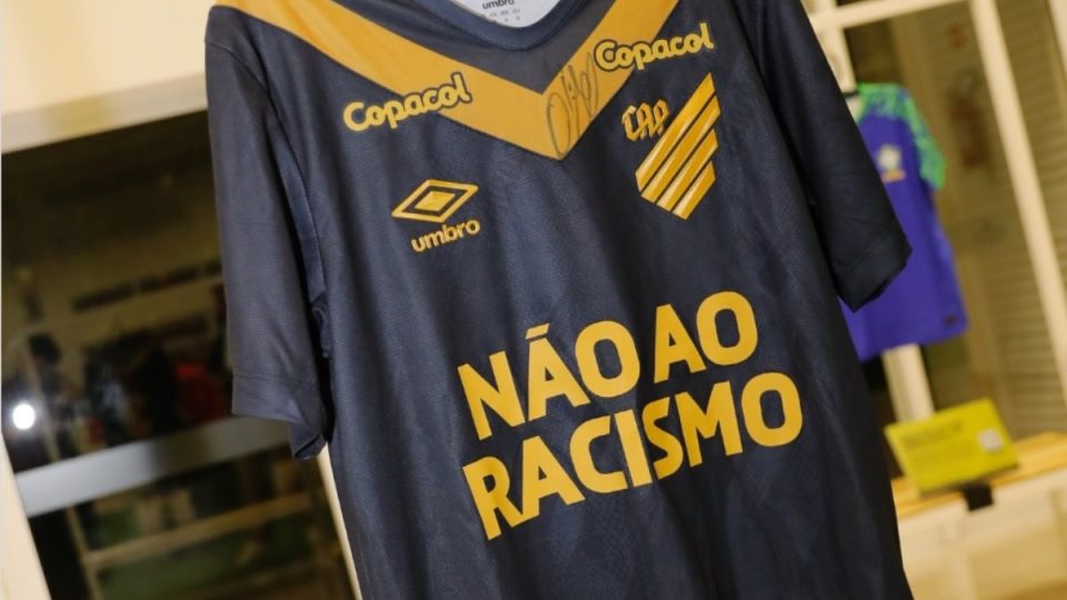Camisa preta do Athletico em exposição com os dizeres "Não ao Racismo" no lugar do patrocinador principal