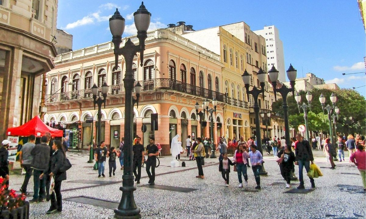A imagem mostra a Rua XV, no Centro de Curitiba, próximo ao local da campanha de orientação sobre o Imposto de Renda 2026.
