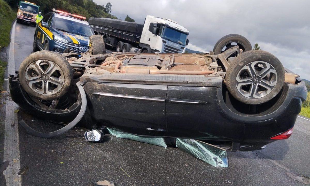 Família sofre capotamento em Campina Grande do Sul, na BR-116, mas somente a mulher sofre ferimentos leves. O carro aparece virado de cabeça para baixo, com vidros e peças quebradas.