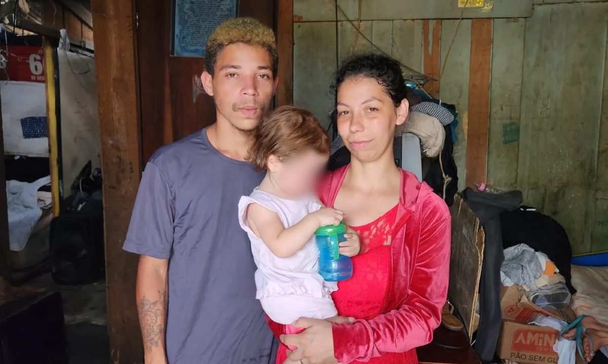 Na foto, a menina Eloah, que foi raptada no bairro Parolin em janeiro de 2025, aparece no colo da mãe e ao lado do pai, em uma casa de madeira
