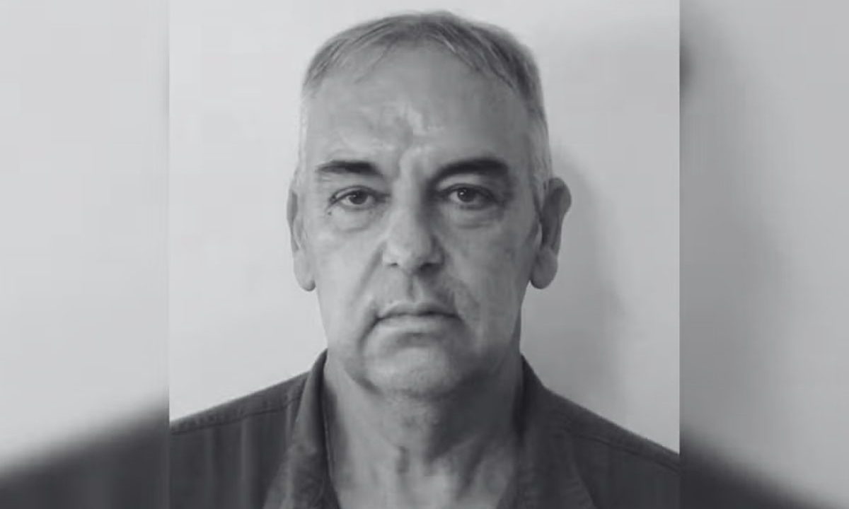 Imagem mostra o chefe José Wilson assassinado a tiros por um funcionário. A imagem está em preto e branco. Ele é um homem idoso, com sobrancelhas bem marcadas e usa camisa preta.