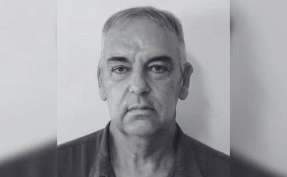 Imagem mostra o chefe José Wilson assassinado a tiros por um funcionário. A imagem está em preto e branco. Ele é um homem idoso, com sobrancelhas bem marcadas e usa camisa preta.