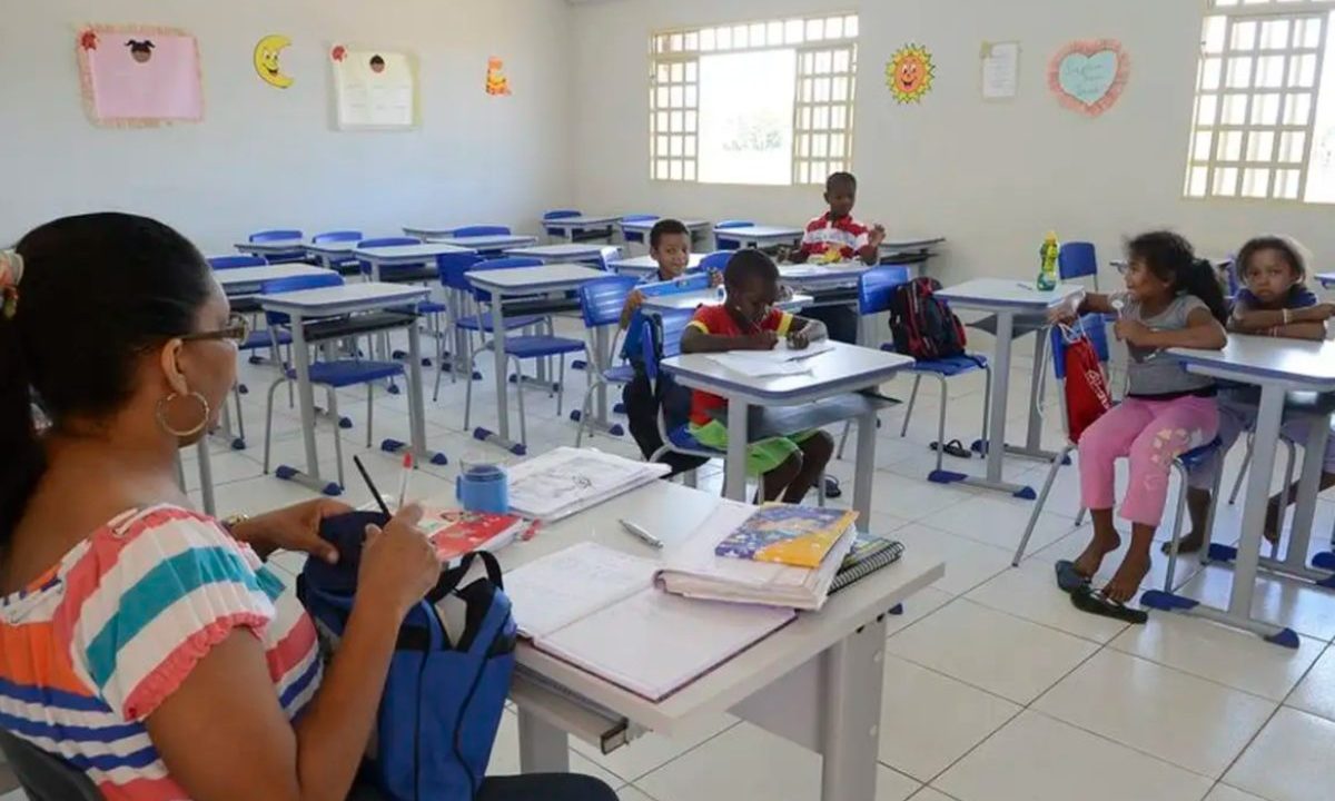 Foto de sala de aula com professora e alunas; imagem usada para ilustrar matéria sobre o concurso 'Enem dos professores'