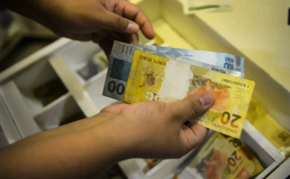 Imagem ilustrativa de notas de R$ 20 e R$ 100, simbolizando a resposta à pergunta: como saber se ganhei na Loteria Federal?