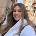 Foto mostra estudante de medicina sorrindo, posando para selfie em um ponto turístico. Ela usa uma jaqueta branca e é loira. Jovem foi morta a facadas no Paraguai