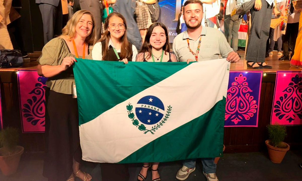 Foto de estudantes do Paraná com a bandeira do estado na Índia