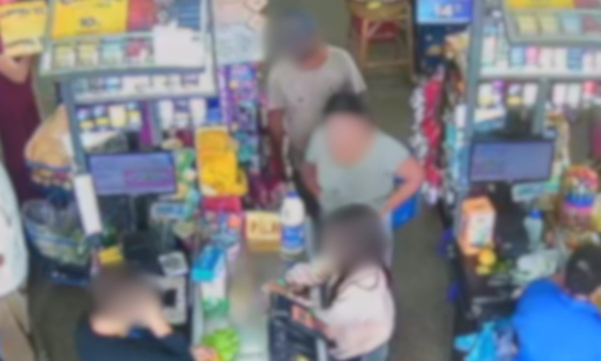 Imagem está borrada para preservar a identidade dos envolvidos e mostra o falso pastor na fila do mercado atrás das meninas. Na rua, ele perseguiu as duas e abordou falando em 'oração gostosa'. Ele está de máscara preta e preta, camiseta cinza. A adolescente está com cabelo preso e camisa verde clara. A criança com cabelo solto e blusa rosa no caixa do mercado.