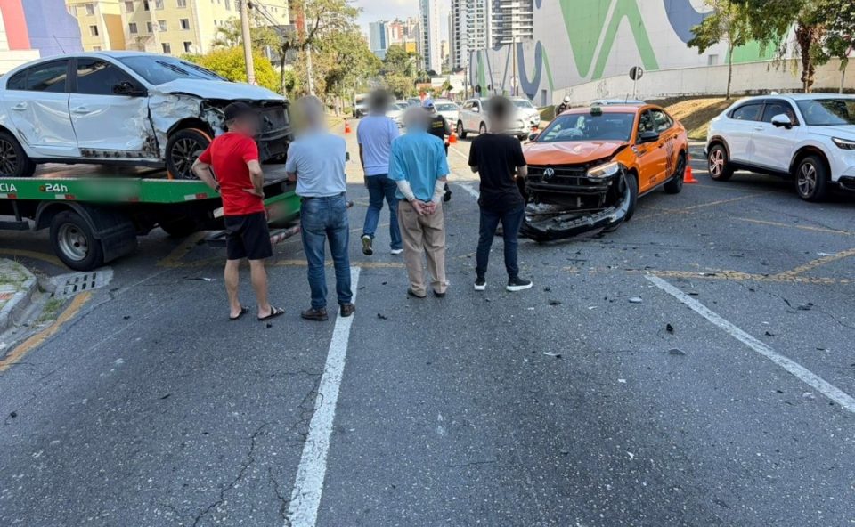 Testemunhas e motoristas envolvidos em batida entre três carros observam cena do acidente registrado em Curitiba; família que voltava de chá revelação ficou ferida.