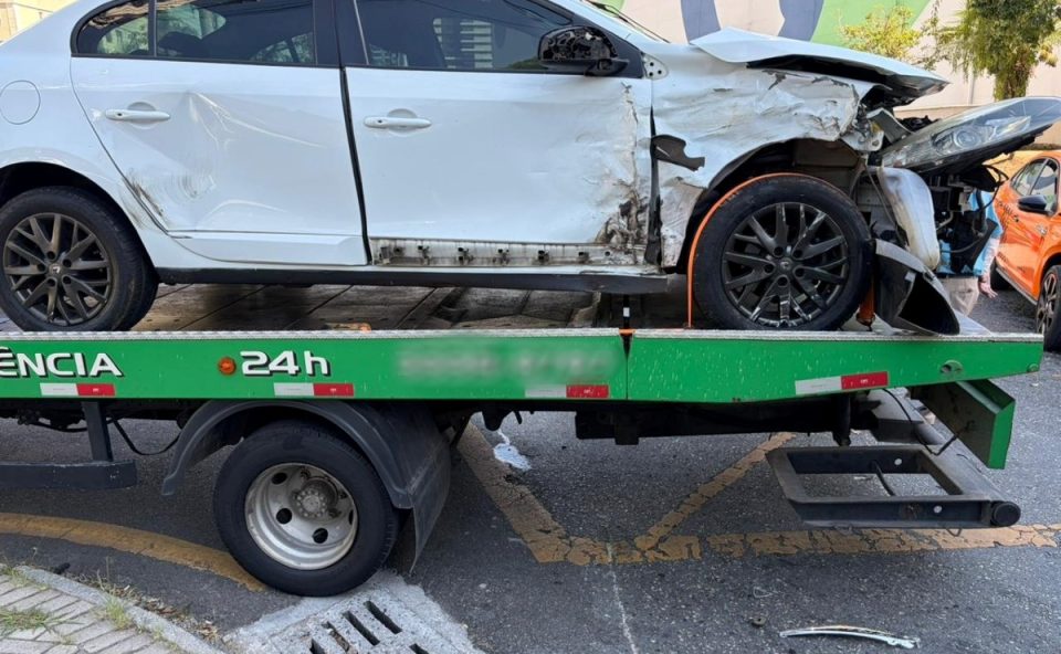 Carro branco envolvido em colisão com três veículos em Curitiba é guinchado. Família que estava em outro carro envolvido voltava de chá revelação.