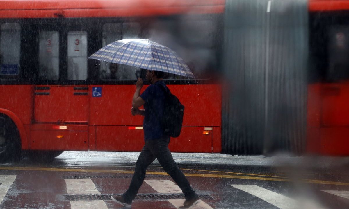 pessoa andando com sombrinha para ilustrar a previsão de frente fria e tempestades em curitiba