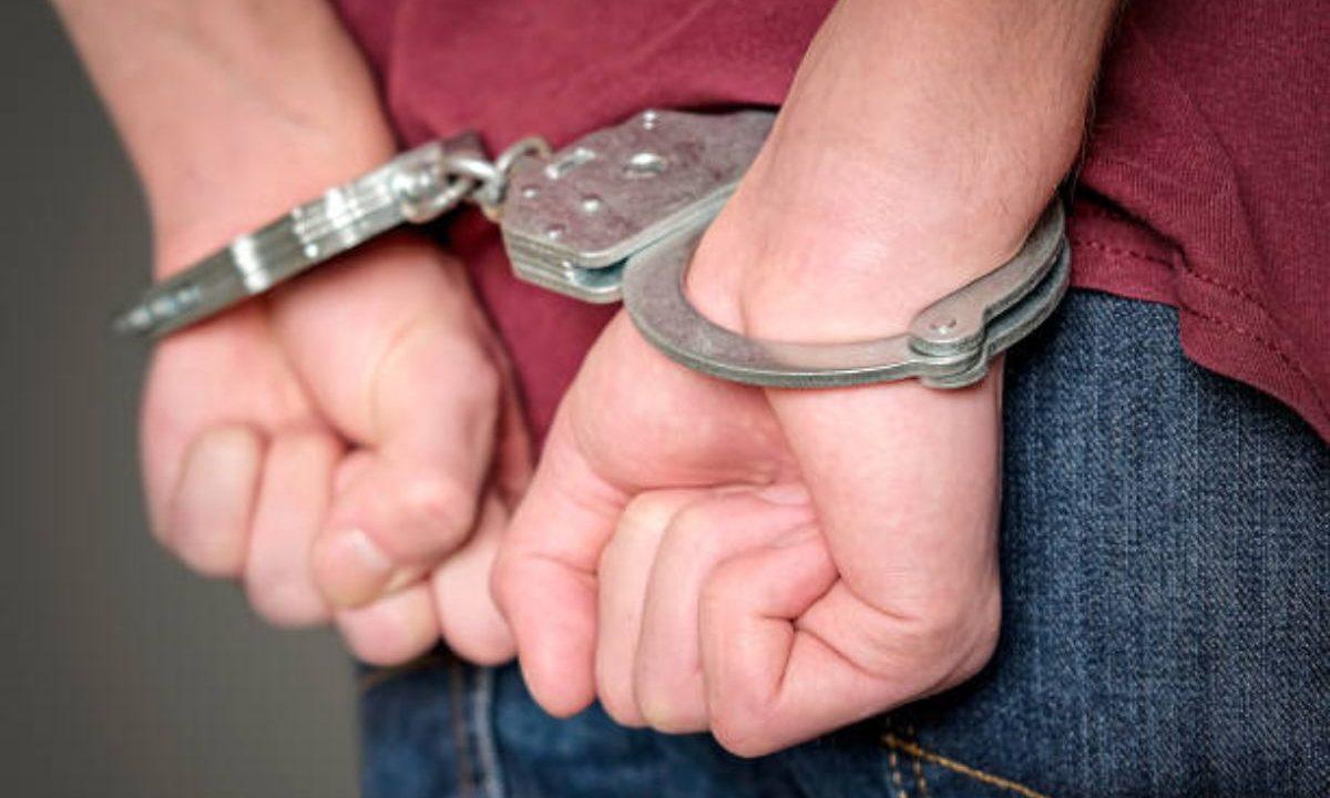 Homem com as mãos algemadas; suspeito de atacar o irmão com sequelas de AVC foi preso