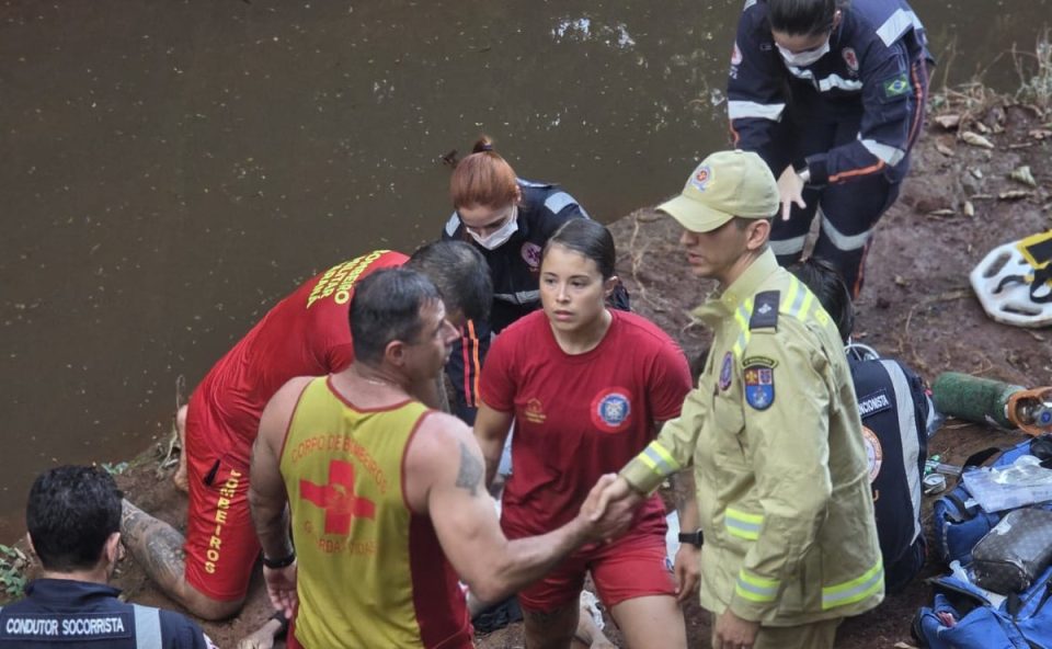 Foto mostra bombeiros se cumprimentando após resgate de homem que morreu afogado ao entrar em córrego para nadar em Sarandi.