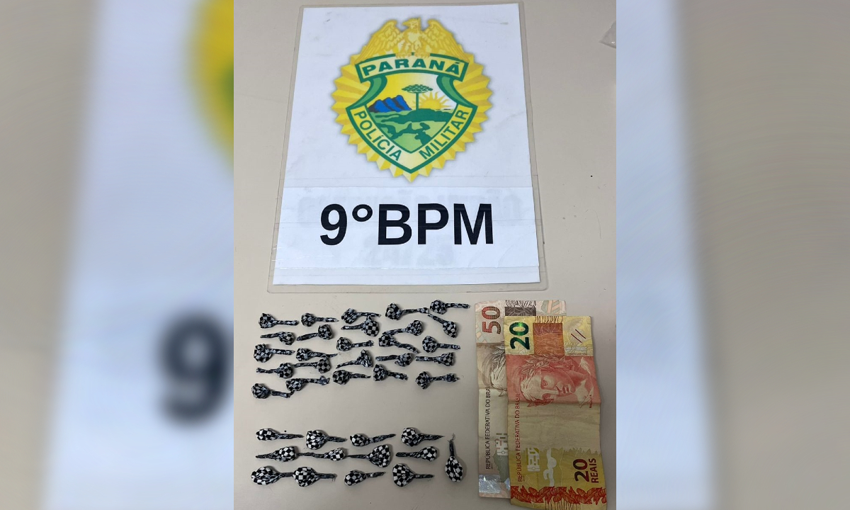 Foto de operação que resultou na operação de um homem, adolescente e drogas em Paranaguá. A imagem mostra papelotes de droga, R$ 70 em papel e símbolo do 9º Batalhão da Polícia Militar.