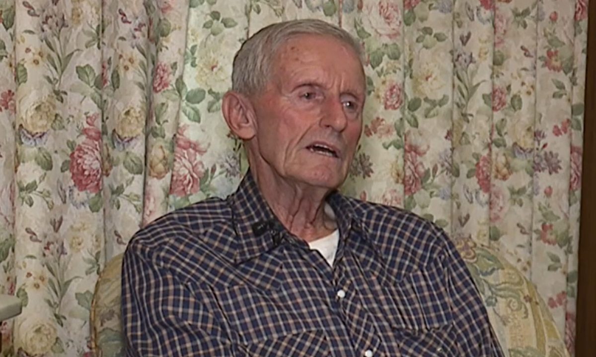 A foto mostra o idoso Mervin Raudabaugh, que se recusou a vender suas terras para instalação de IA. Ele é um homem de 86 anos, cabelos brancos e camisa bordô.
