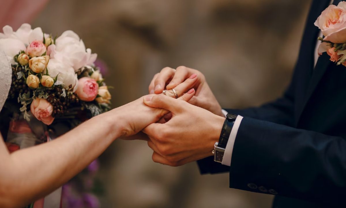 Homem colocando uma aliança da mão de mulher para ilustrar o casamento coletivo para moradores de Curitiba e Região Metropolitana.